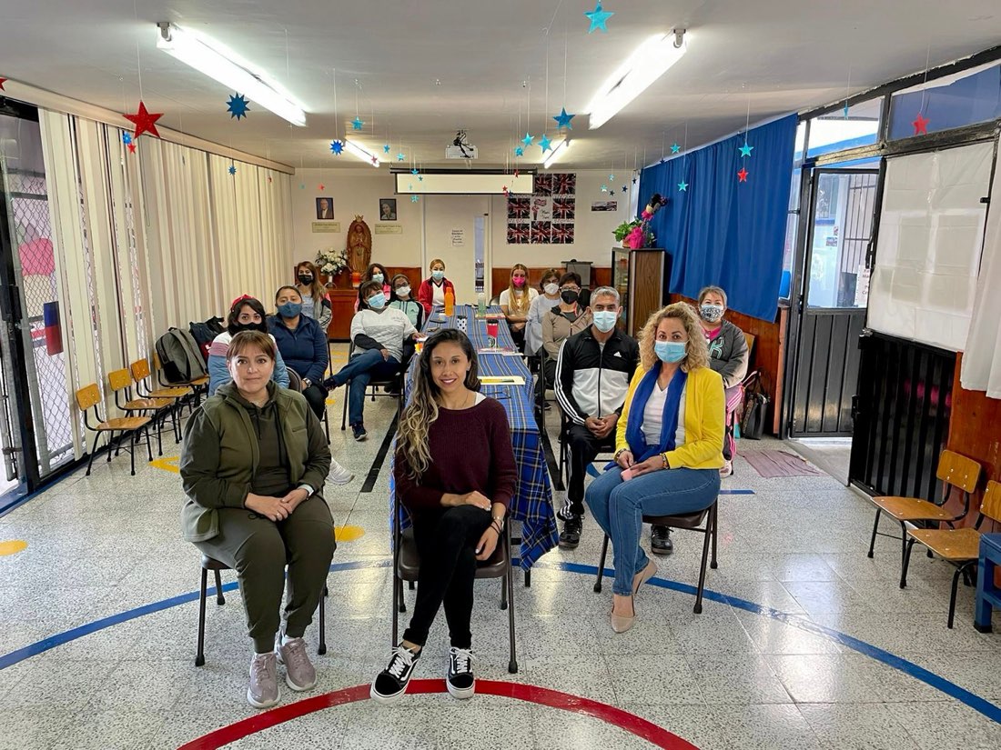 Paulina con un grupo de participantes en una escuela